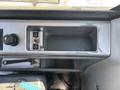Close-up of the control panel of a 2010 Bobcat E80 showing a key slot a switch panel and an empty compartment for storage or tools