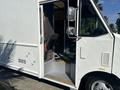 A 2012 Ford E-450 truck with an open driver side door and a visible interior seat