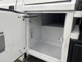 An open compartment on a 2014 Ford F-550 with a gray interior and a key hanging from a hook inside
