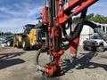 A 2018 Sandvik Ranger DX800 drill rig with a red and black color scheme, featuring articulated arms and hoses, positioned prominently in the foreground