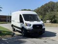 A 2022 Ford Transit white cargo van parked at an angle with a black grille and large front windshield