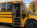 A 2022 Freightliner B2 school bus with its door open and steps leading inside