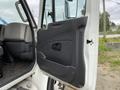 The interior door of a 2014 International Durastar truck featuring a black panel with a handle and a speaker grille visible
