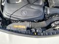 Engine compartment of a 2014 Mercedes-Benz CLA-Class showcasing the engine cover and air intake hose