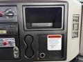 Dashboard of a 2011 International 4300 featuring gauges controls a warning label and a storage compartment