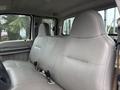 The interior of a 2008 Ford F-250 SD showing two gray leather front seats with seatbelts and a spacious back seat area