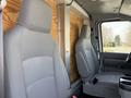 Interior view of a 2023 Ford E-450 showing two gray seats with adjustable headrests and a center console between them