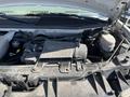 The image shows the engine compartment of a 2013 Chevrolet Express with a Vortec engine and various components such as hoses and a fluid reservoir