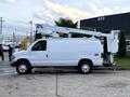A white 2007 Ford Econoline van with a raised aerial lift attached to its roof