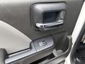 Close-up of the interior door handle and window control of a 2016 GMC Sierra 1500 featuring a textured surface and chrome accents