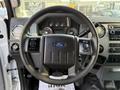 Steering wheel of a 2015 Ford F-550 with controls and dashboard instruments visible in the foreground