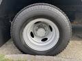 Close-up of a silver wheel and tire from a 2018 Ford Econoline showing detailed wheel design and tread pattern