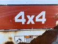 Close-up of the 4x4 emblem on a Bobcat 5600 vehicle showcasing large white numbers on a red background with some visible wear and rust
