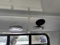 Interior view of a 2018 Chevrolet Express showing overhead lights and speakers mounted on the ceiling