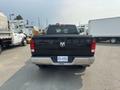 A black 2015 RAM 1500 pickup truck viewed from the rear with the tailgate down and visible license plate