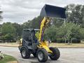 A 2014 Wacker Neuson WL34 compact wheel loader with a yellow arm and front bucket positioned upright