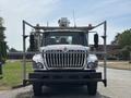 A 2012 International 7300 Workstar truck with a large silver grille orange lights on top and a sturdy metal frame attached to the front