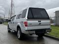 Silver 2014 Ford F-150 with a truck cap is parked showing the rear and side view with chrome accents and XTR designation