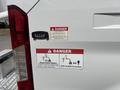 A 2019 Ford Transit 350 with warning signs indicating electrocution hazard and advising to stay clear of the machine