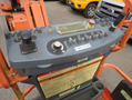 Control panel of a 2009 JLG E300AJP with levers buttons and a digital display for operating the machine