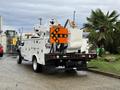 A 2008 Ford F-550 utility truck with a bucket lift and an orange traffic arrow sign mounted on the back