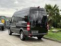 A black 2017 Mercedes-Benz Sprinter van parked with its rear facing the viewer showcasing a sleek design and large windows