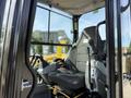 A close-up view of the operator seat and controls in a 2022 Caterpillar 306 excavator with ergonomic levers and pedals