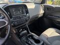 Interior view of a 2017 Chevrolet Colorado featuring a dashboard with a touchscreen display and controls alongside a gear shift and console area