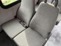 Two gray upholstered seats from a 2014 Ford Econoline van with seat belts attached