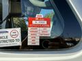 A red British Columbia Certificate of Approval sticker with the year 2026 and months listed from January to September on a vehicle window