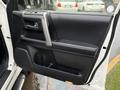 The interior driver's side door of a 2018 Toyota 4Runner featuring a black panel with a silver handle and storage compartment