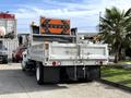A 2012 International 4300 truck with a flatbed and a yellow and orange directional sign mounted on the rear