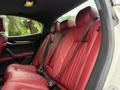Interior seating of a 2016 Maserati Ghibli featuring red leather upholstery with a sleek design and seatbelts fastened