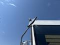 A 2012 Ford Econoline with a side mirror reflecting sunlight and a clear sky in the background