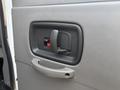 A close-up view of the interior door handle and lock mechanism of a 2021 Chevrolet Express
