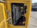 Close-up view of a 2022 Caterpillar 306 engine compartment showing the cooling radiator and associated components in a bright yellow casing