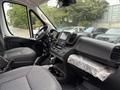 Interior of a 2023 RAM Promaster 3500 featuring a driver's seat, steering wheel, dashboard with touchscreen display and center console with cup holders and storage compartment