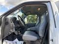 Interior view of a 2016 Ford F-750 featuring two grey vinyl seats and a dashboard with various controls and displays