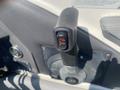 Black control lever with an orange button labeled with a temperature symbol in a boat's cockpit