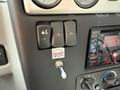 Close-up view of a control panel featuring three black switches and a radio with a knob and display indicating radio frequency and other controls