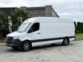 A 2019 Mercedes-Benz Sprinter van with a white exterior and a black stripe along the bottom, featuring a high roof and large cargo space
