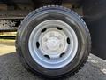 A close-up view of a silver wheel with a tire mounted on a 2014 Hino 195 showcasing the wheel's details and tread design