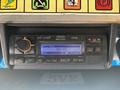 A close-up of a 2012 Ford E-450 radio and control panel featuring a display showing 92.7 MHz and various buttons for tuning and audio settings