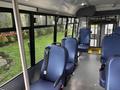 Interior of a 2021 Ford Transit-350 with blue seats arranged in rows and safety signage on the windows