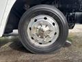 A close-up view of a chrome wheel rim with multiple bolts and a thick black tire on a 2020 Freightliner MT45