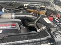 The image shows the engine compartment of a 2005 Ford F-350 SD highlighting the powerful diesel engine components and intricate tubing and wiring connections