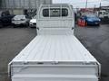 A 2008 Suzuki Carry with an empty flatbed and a white exterior is shown from the rear angle with the tailgate down