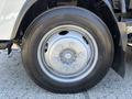 Close-up of a silver wheel with a six-bolt pattern and a Bridgestone tire mounted on a 2016 Isuzu NPR-HD vehicle