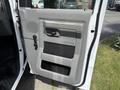 A gray door panel of a 2018 Ford E-450 with a handle and window controls