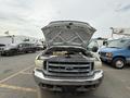 A 2004 Ford F-350 SD with its hood raised exposing the engine compartment and front grille